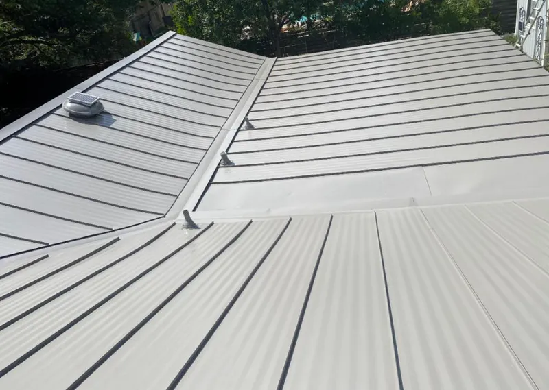 Solar attic fan installed on a metal roof for Roof Ventilation in Urbana